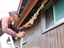 軒下に短冊状の干し大根を吊るす